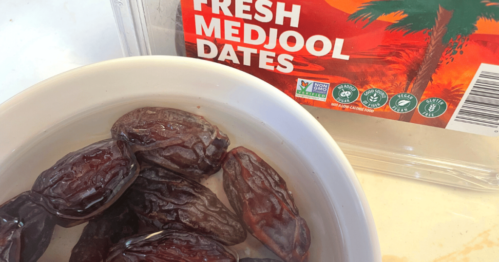 A close-up photo of plump and juicy dates soaked in water, ready to be used in the energy balls recipe.
